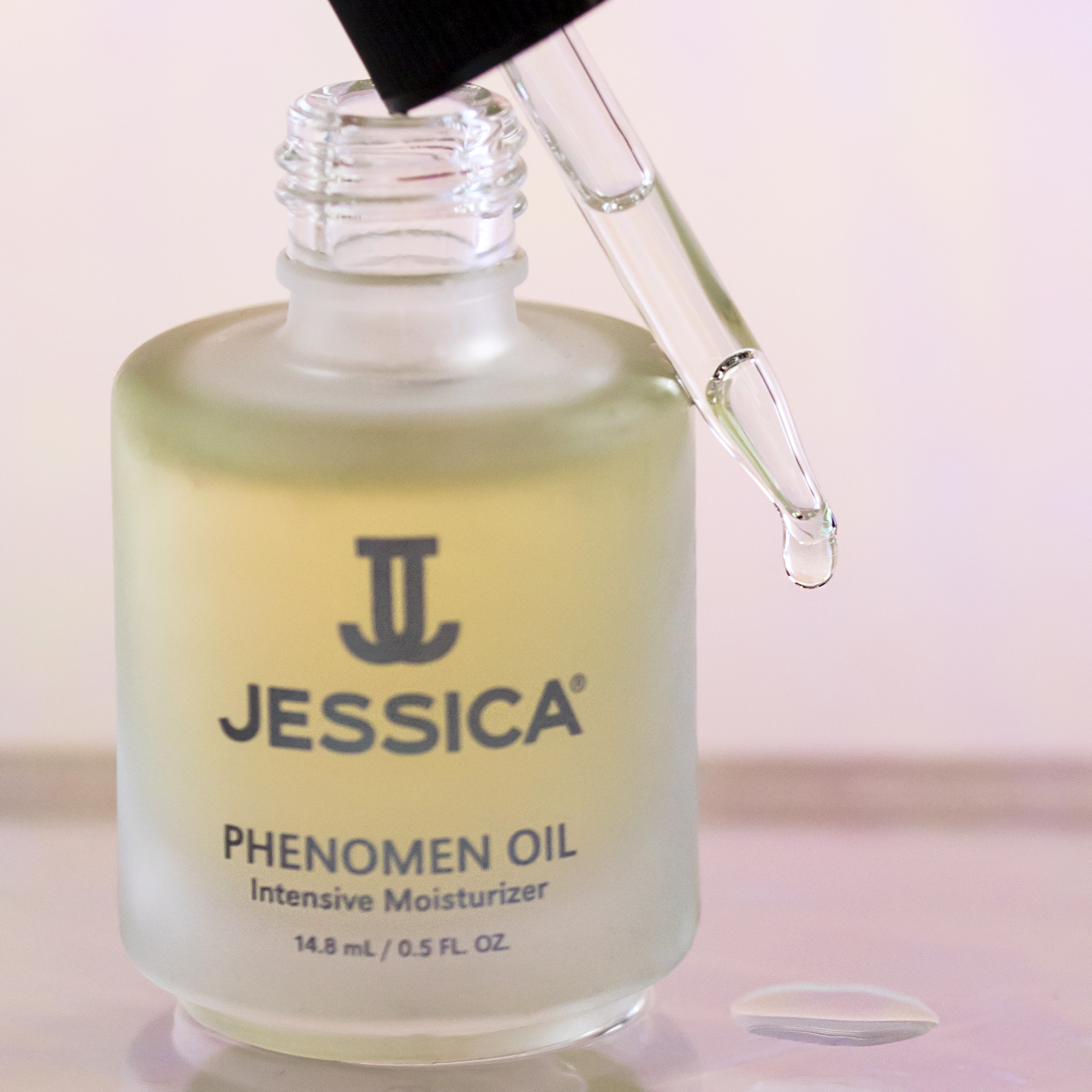 Open bottle of Phenomen Cuticle Oil with a glass dropper dispensing oil